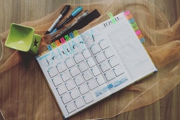 calendar on a table with colored pens and sticky noes